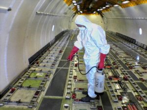 Desinfektion des Frachtraumes eines Transportflugzeuges. Ausbringung des Desinfektionsmittels im Spritzverfahren.